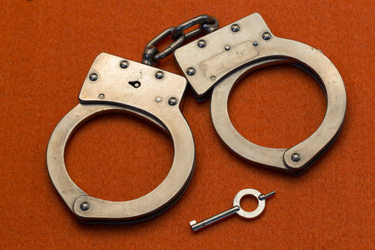 Metal Handcuffs on OrangeBackground