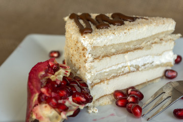 Portion homemade cream cake with pomegranate seeds and chocolate spread. Macro view. 
