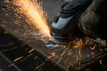Worker cutting metal with grinder.Spark while grinding iron