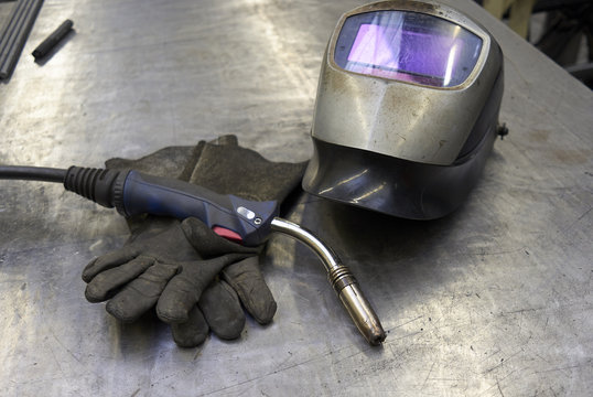 Welder Equipment, Torch, Gloves And Shield On A Metal Plate