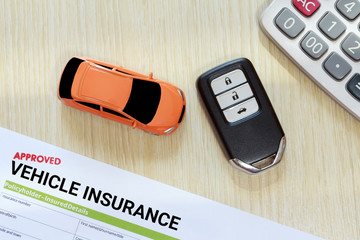 Top view of approved vehicle insurance with car key, car toy