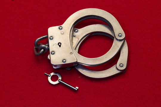 Metal Handcuffs on Red