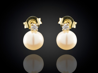 Golden earrings with pearl isolated on black background