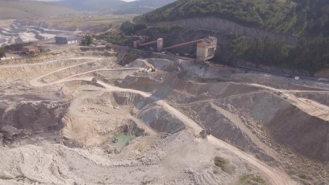 Aerial view on bucket wheel excavator and big dump truck in coal mine.
