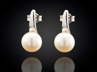 Golden earrings with pearl isolated on black background
