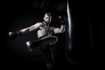 Plakat Male Athlete boxer punching a punching bag with dramatic edgy li