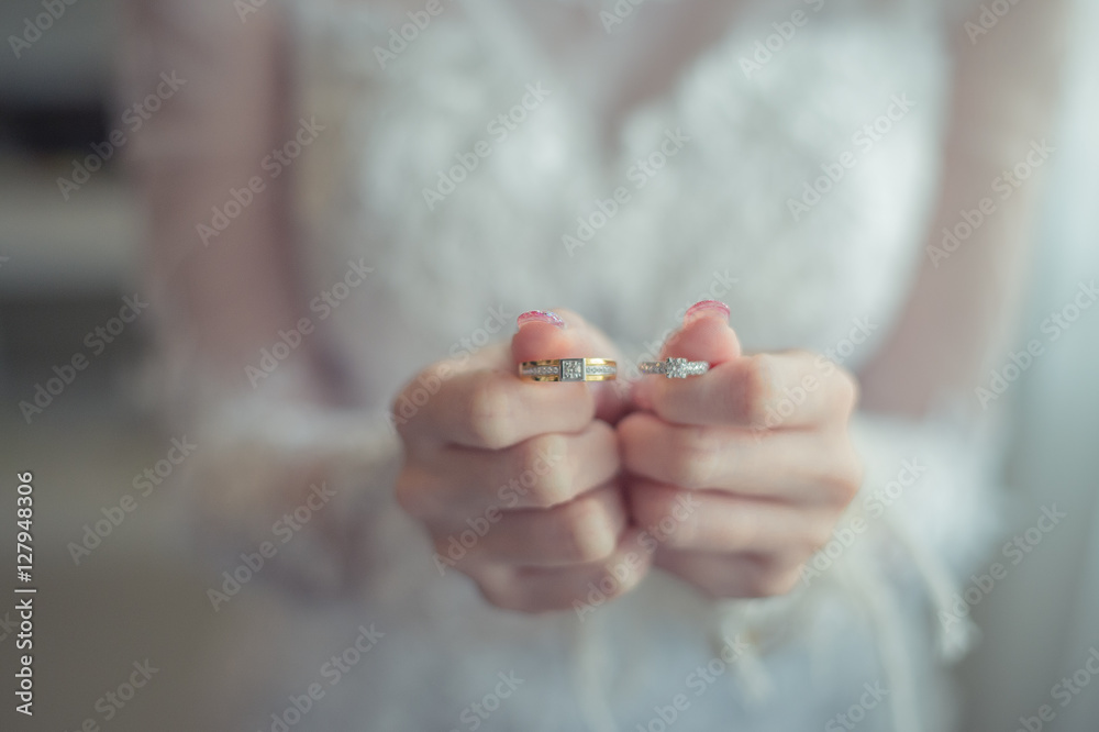 Wall mural close up bride holds beautiful wedding ring on hand.