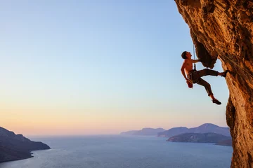 Poster Rock climber resting while climbing overhanging cliff © Andrey Bandurenko