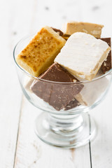 Variety of Christmas nougat in crystal glass on white wooden background

