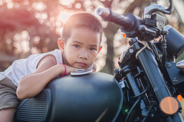 Little kid  on classic motocycle in park.