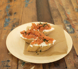 Salmon and cream cheese sandwiches on a wooden table