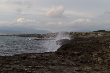Dark view of coast. Water splashing on rocks.