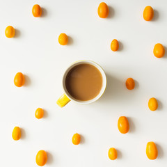 Colourful bright pattern made of kumquat fruit with coffee cup.