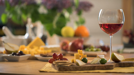 glass of red wine with a snacks stand on the kitchen table - 127953373