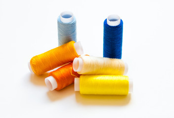 multicolored spools of thread on white background