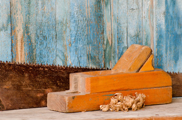 Old wooden planer and saw on vintage background, close-up