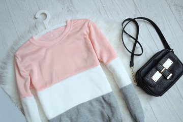 Fashion concept, pink and white sweater and handbag, top view