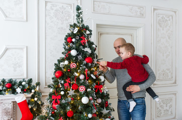 Obraz na płótnie Canvas Father and son are decorating the Christmas tree