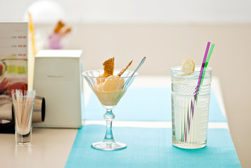 Fruity ice cream dessert and cold lemonade squash with lemon slice