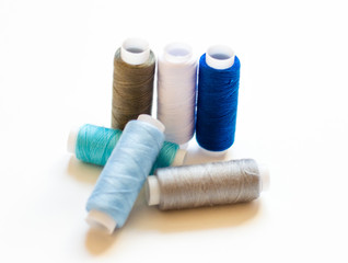 multicolored spools of thread on white background
