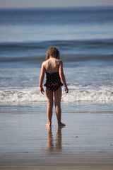girl at beach playing in the ocean during a warm sunny day