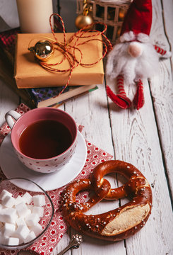Christmas tea party table with cup of tea, pretzel and decoratio