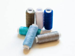 multicolored spools of thread on white background