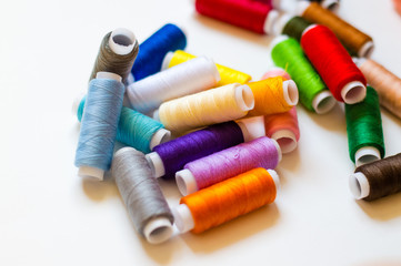 multicolored spools of thread on white background