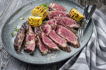 Barbecue Rib Eye Steak aufgeschnitten auf Teller