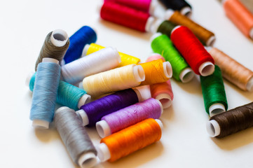multicolored spools of thread on white background