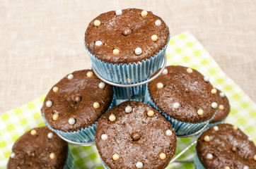 Chocolate muffins in a cute holder.A pile of cacao muffins with candy on top.
