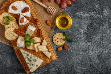 Fototapeta na wymiar Assortment of cheese with honey, nuts and grape 