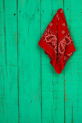 Red bandana hanging on rustic antique green wood door