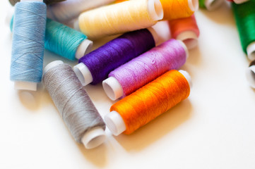 multicolored spools of thread on white background