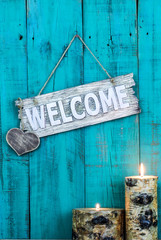 Welcome sign with heart  hanging by candles