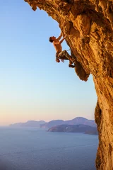 Deurstickers Rock climber on overhanging cliff © Andrey Bandurenko