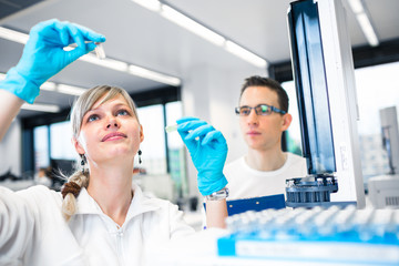 Two young researchers carrying out experiments in a lab