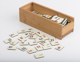 wooden box of rummikub with pieces, white background