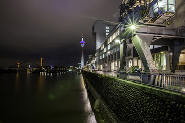 Beleuchteter Handelshafen in Düsseldorf bei Nacht
