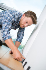 young handyman bending down on a wooden floor