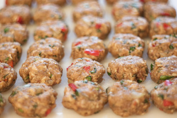 uncooked meatballs on white board