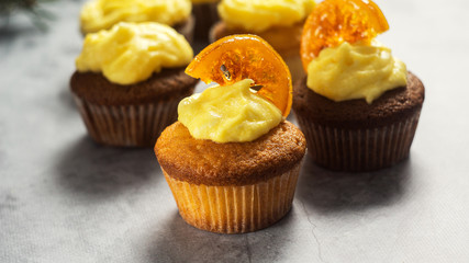 Tasty cupcakes with caramelized orange on table close-up