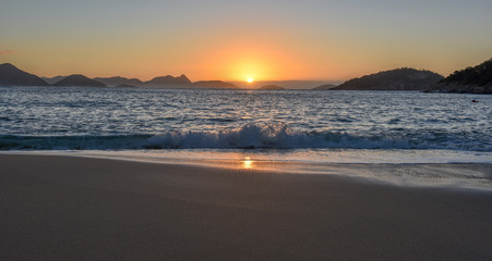 Beautiful Sunrise with the sun rising out of the ocean at the Red Beach, Praia Vermelha, with the Sugarloaf Mountain, Rio de Janeiro