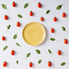 Empty plate, cherry tomatoes and basil leaves pattern.