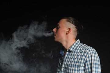 Obraz na płótnie Canvas young man smoking electronic cigarette
