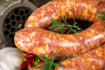 Close-up of rosemary on raw sausages and meat grinder