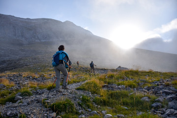 Fototapeta premium Mountain hikers at sunrise on a rocky path