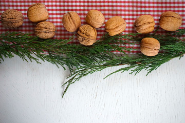 White red checkered fabric and green Christmas tree background with nuts