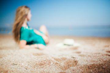 woman girl with hat in turquoise laying on beach at sea ocean
