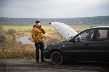 man with broken car